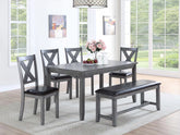 6 Pc grey wood dining set with bench and 4 X-back chairs in a dining room