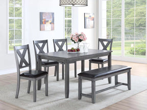 6 Pc grey wood dining set with bench and 4 X-back chairs in a dining room